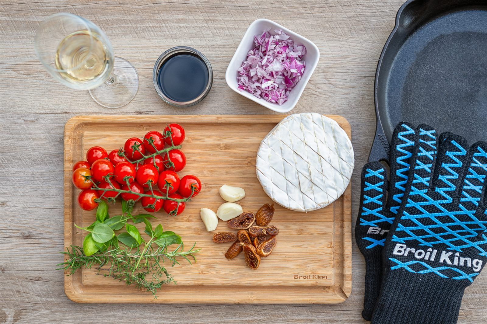 Zutaten fuer gegrillten Camembert: Cherrytomaten, Knoblauch, getrocknete Feigen, Basilikum, Thymian und Rosmarin