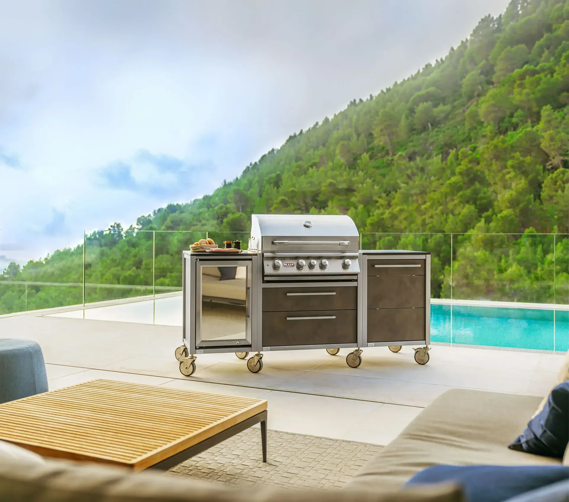 Kompakter BURN BBQ Block auf Rollen auf einer Terrasse am Pool