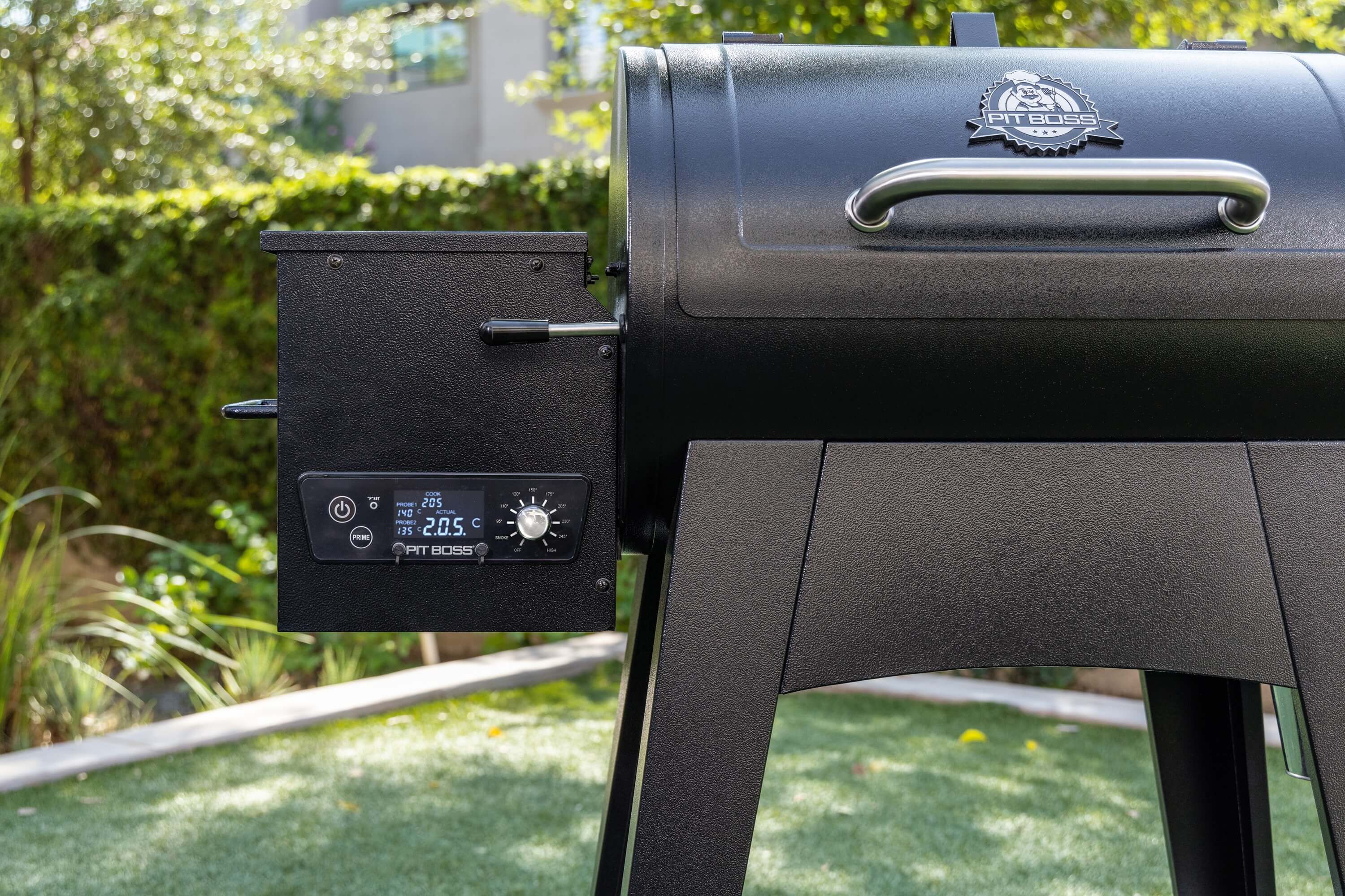 pit-boss-pelletgrill-mit-digitalem-bedienfeld-und-temperaturanzeige-nahaufnahme-der-seitensteuerung-und-garkammer-im-sonnigen-garten