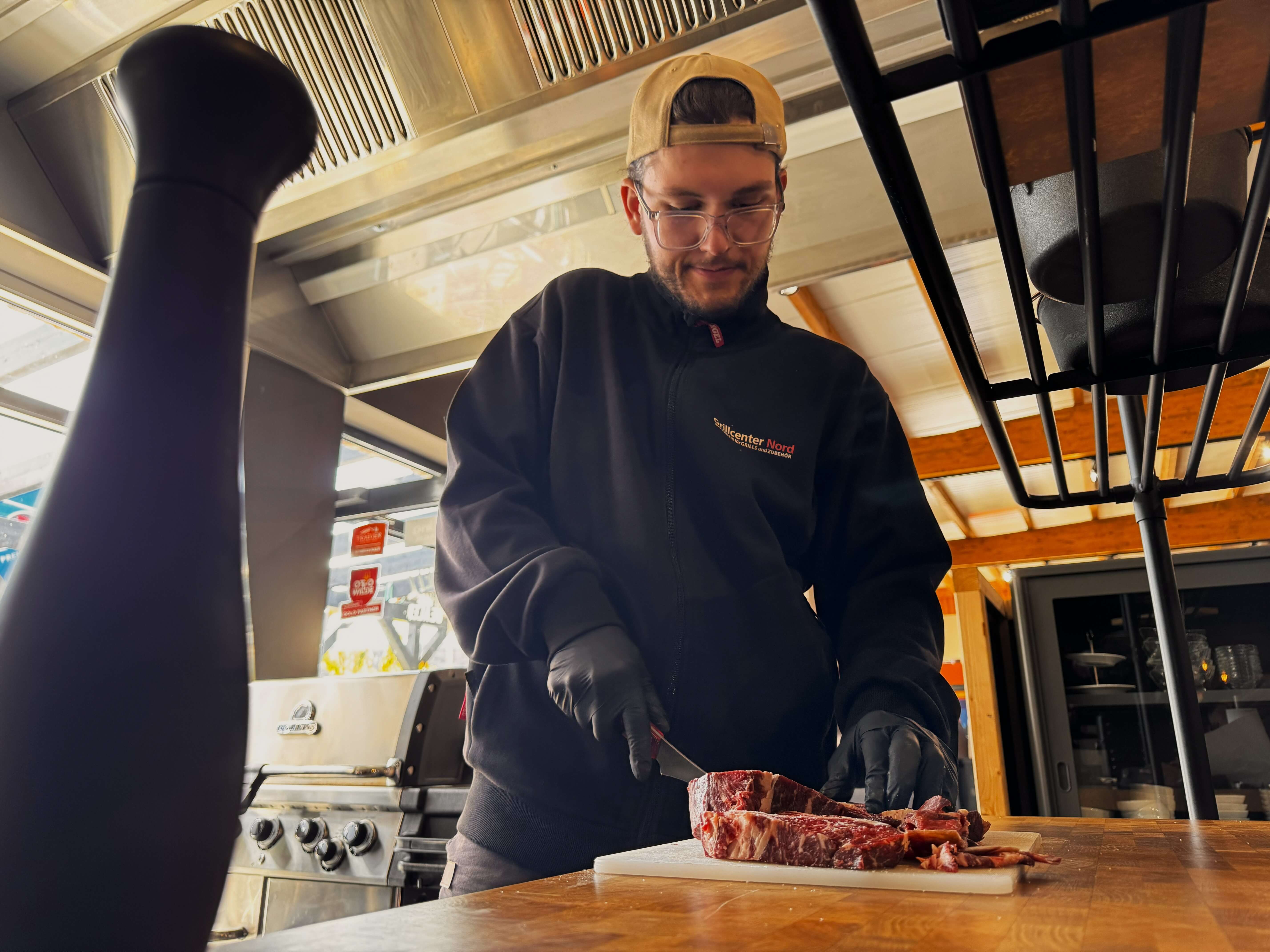 Julius vom Grillcenter Nord portioniert ein Rib-Eye auf dem Schneidebrett