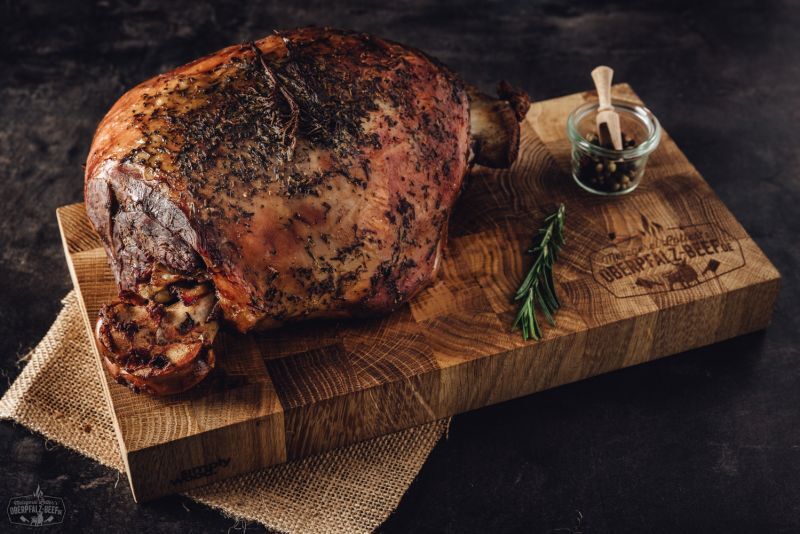 Saftige, gegrillte Lammkeule auf Holzbrett